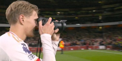 Martin Odegaard picks up the club photographer's camera to snap the fans and players at The Emirates.